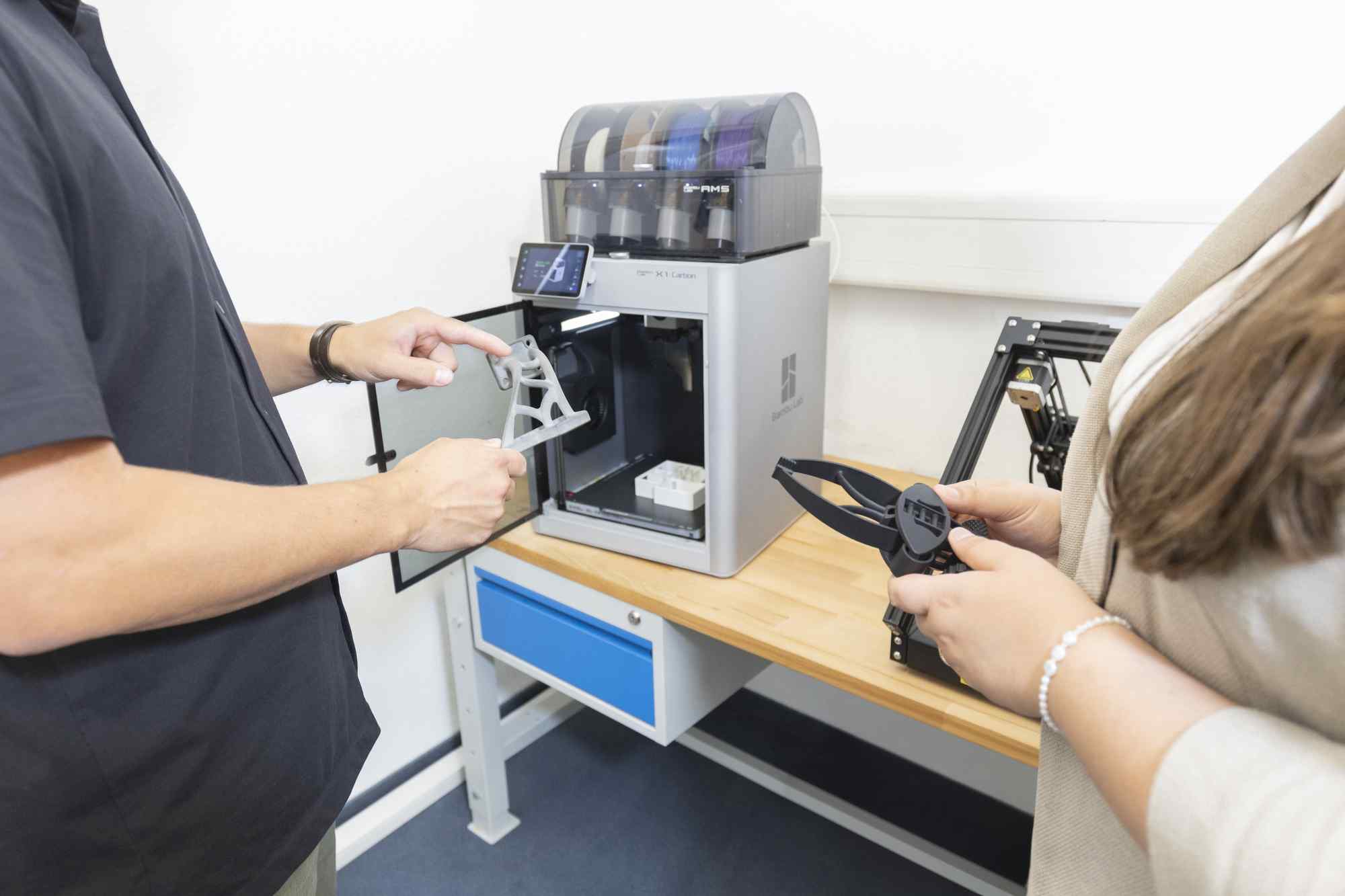 Zwei Personen bedienen einen 3D-Drucker im Digitalisierungszentrum Ulm.