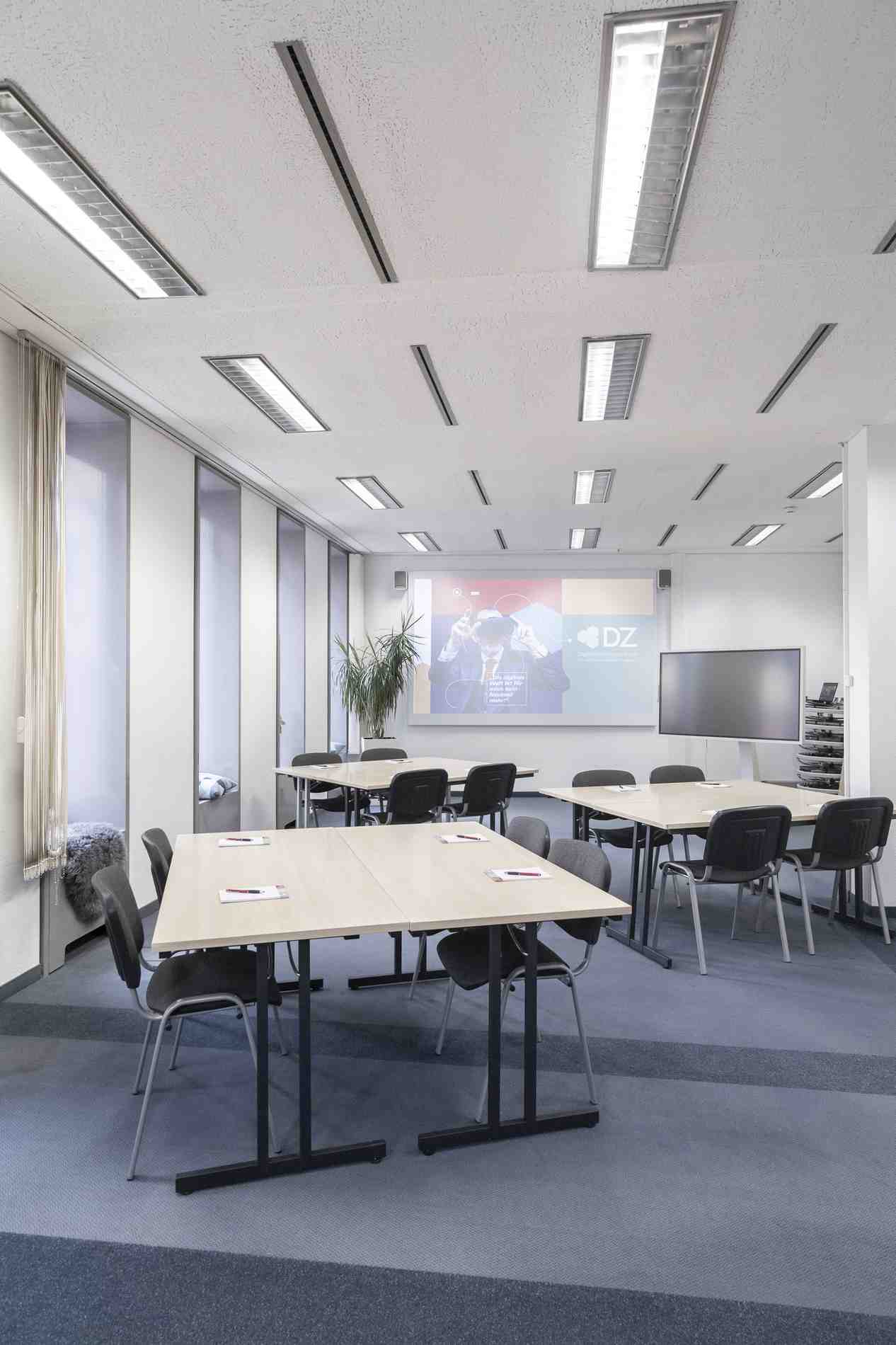 Moderner Konferenzraum im Digitalisierungszentrum Ulm mit Tischen und Stuehlen.