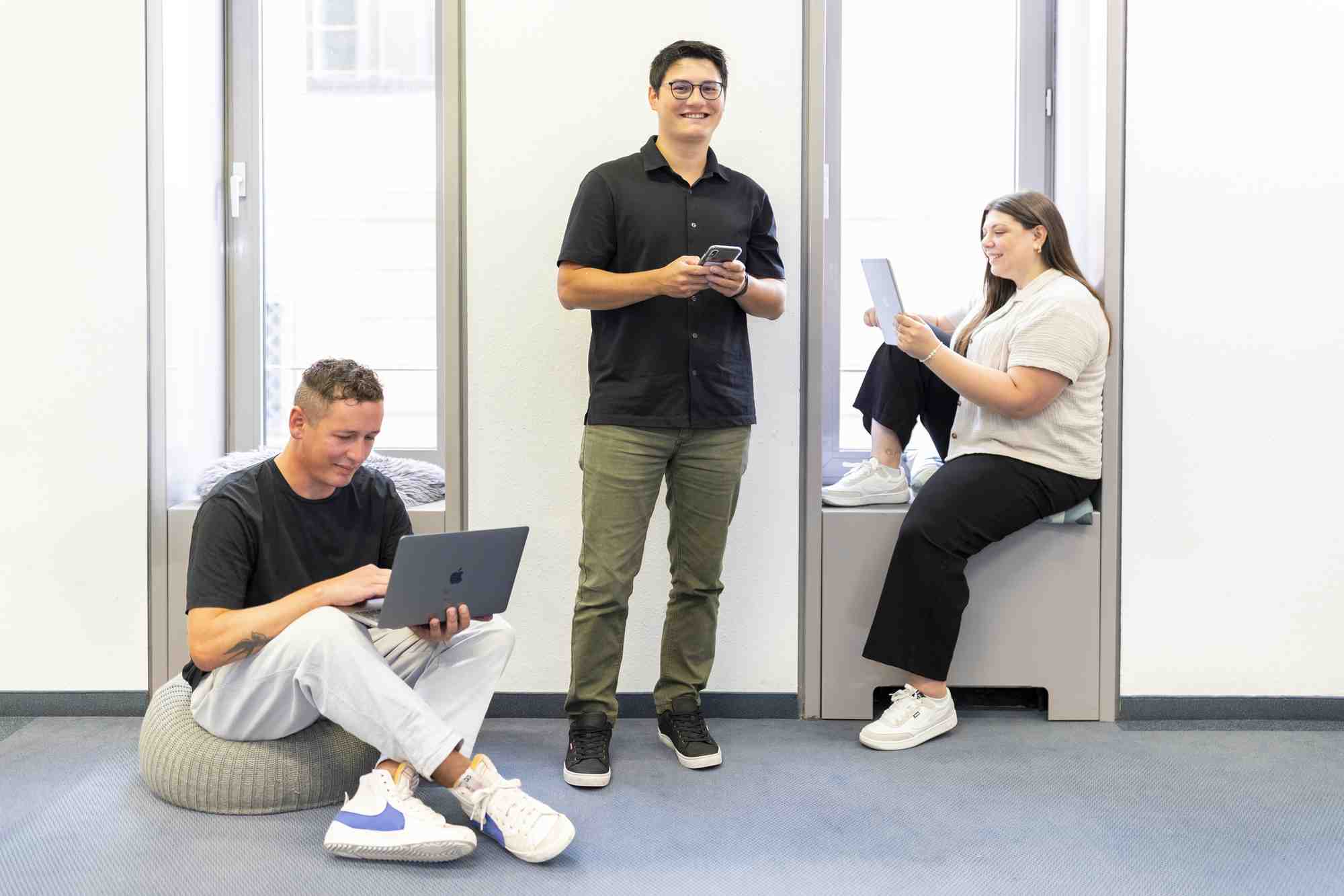 Drei Personen arbeiten laechelnd im Digitalisierungszentrum Ulm Alb Donau Biberach Neu-Ulm.