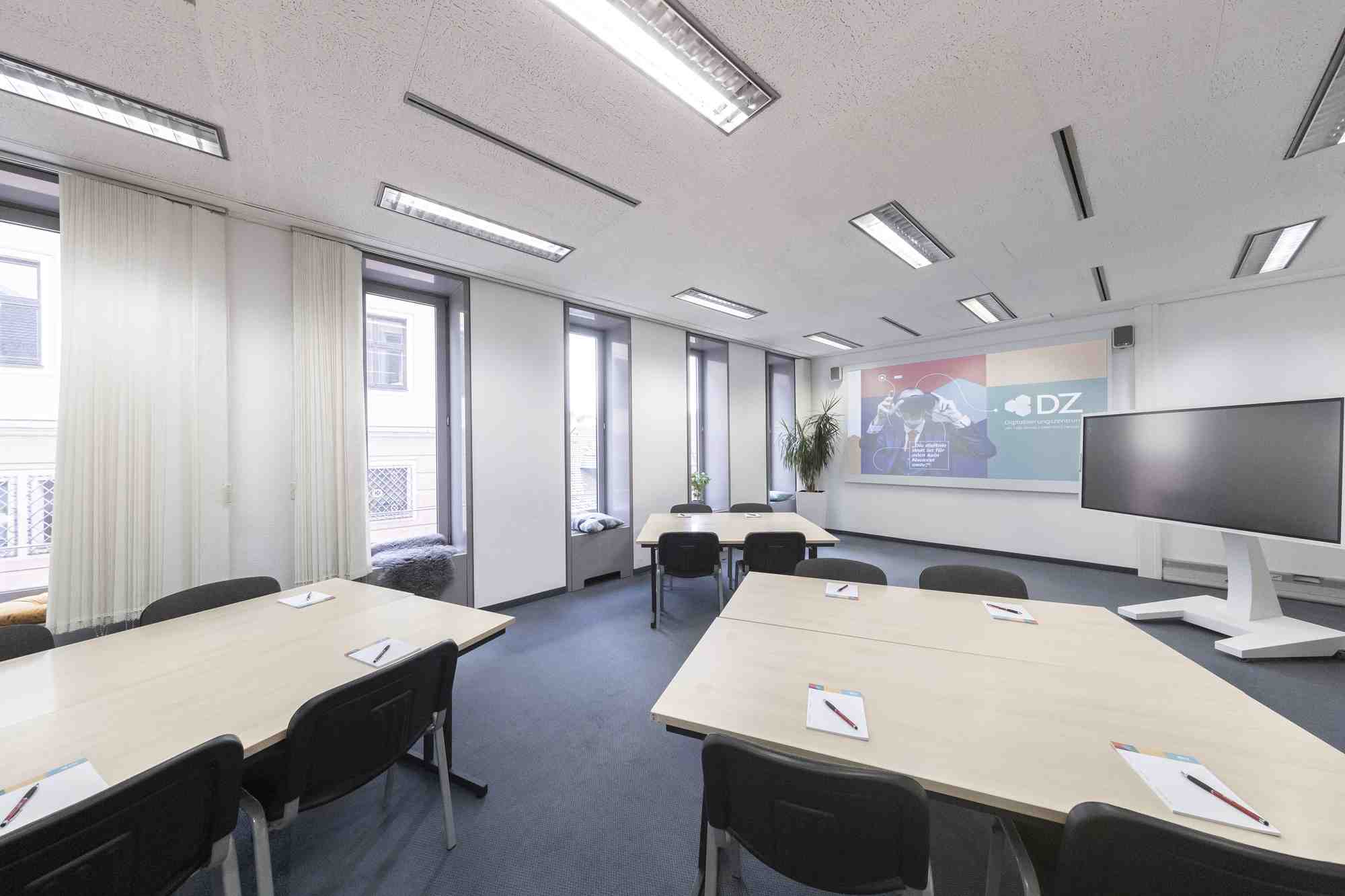 Heller Seminarraum im Digitalisierungszentrum Ulm mit Schreibtischen und Stuehlen