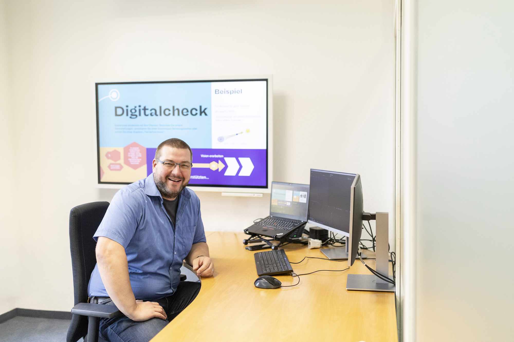 Person sitzt an einem Schreibtisch vor einem Computer im Digitalisierungszentrum Ulm.