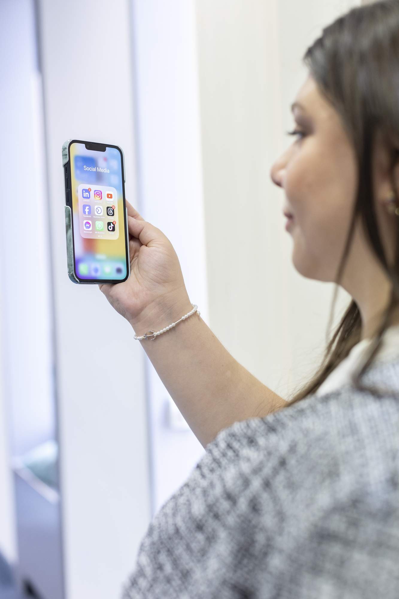Eine Frau betrachtet ein Smartphone im Digitalisierungszentrum.