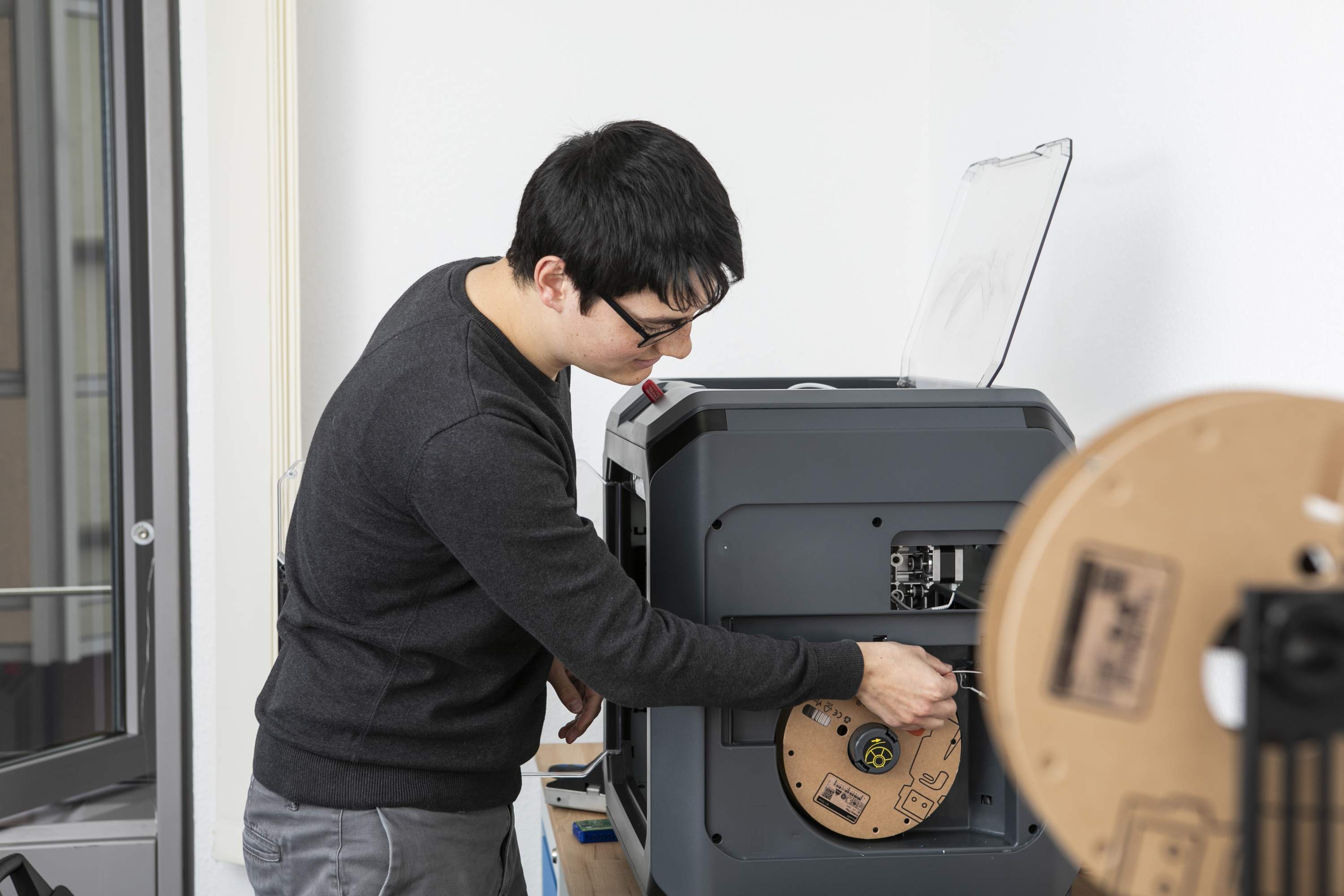 Mann bedient einen 3D-Drucker.