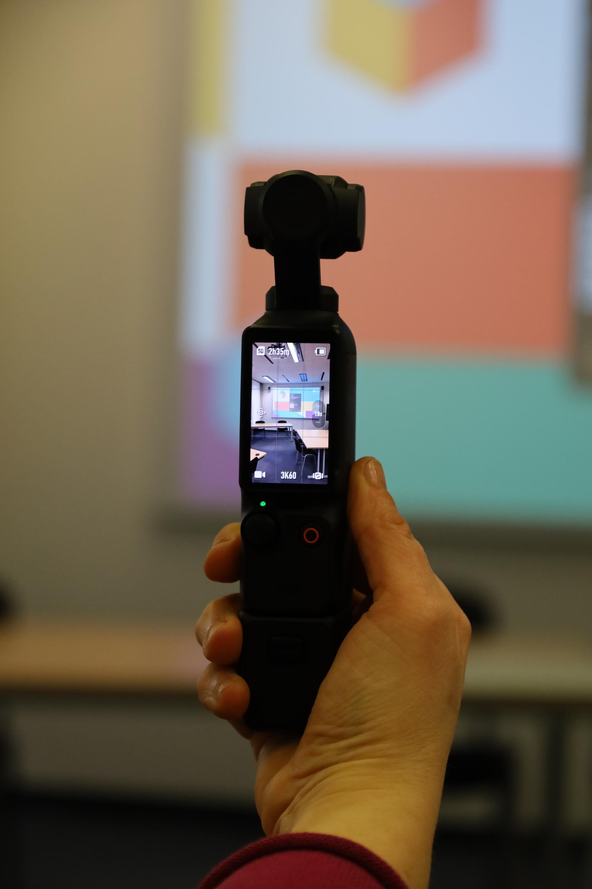 Frau hält eine 360 Grad Kamera in der Hand.