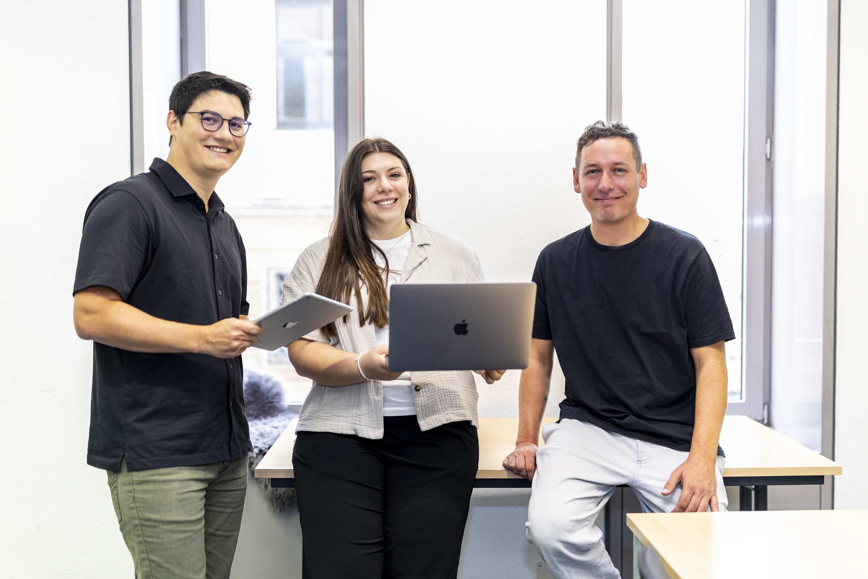 Eine Gruppe von drei Personen mit Laptops und Tablets in einem Buero im Digitalisierungszentrum Ulm.