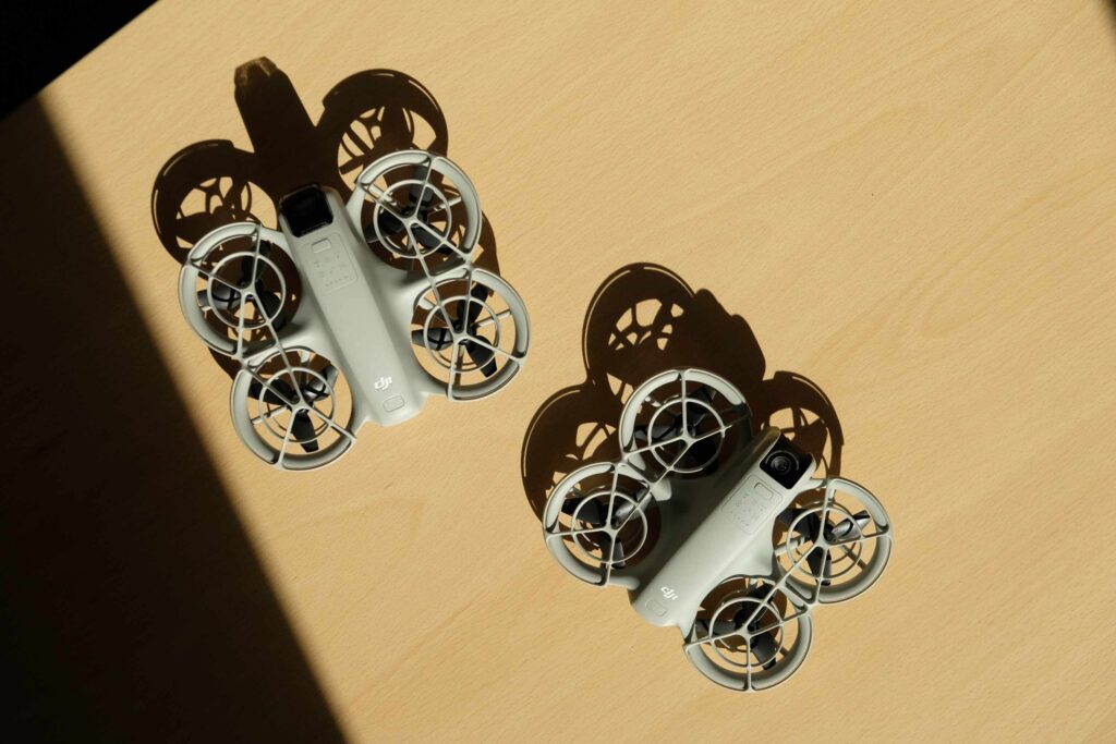 2 Drohnen von DJI liegen auf einem Holztisch.