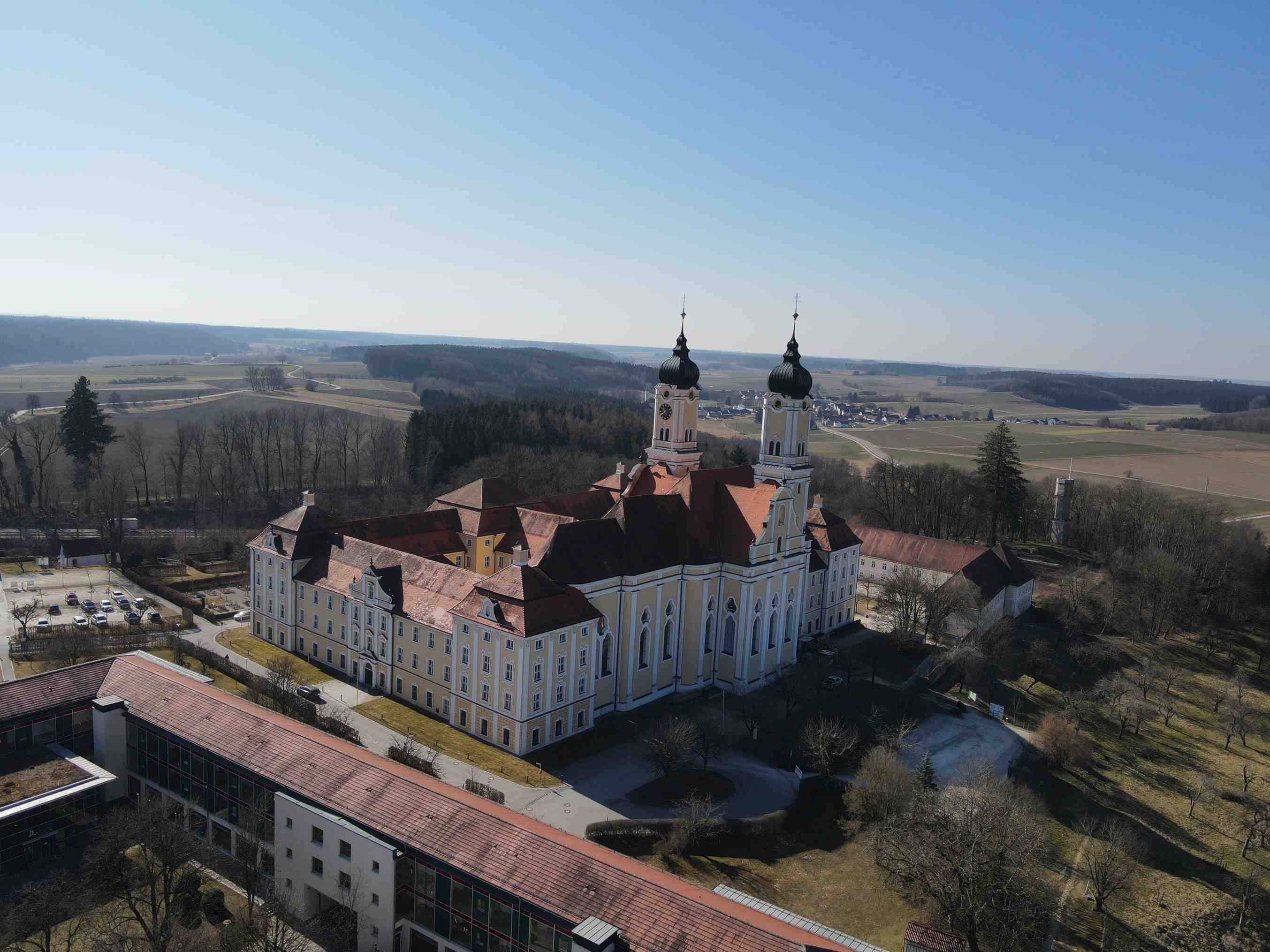 Luftaufnahme eines großen historischen Gebaeudes in einer laendlichen Umgebung mit zwei Tuermen. ?????????????????
