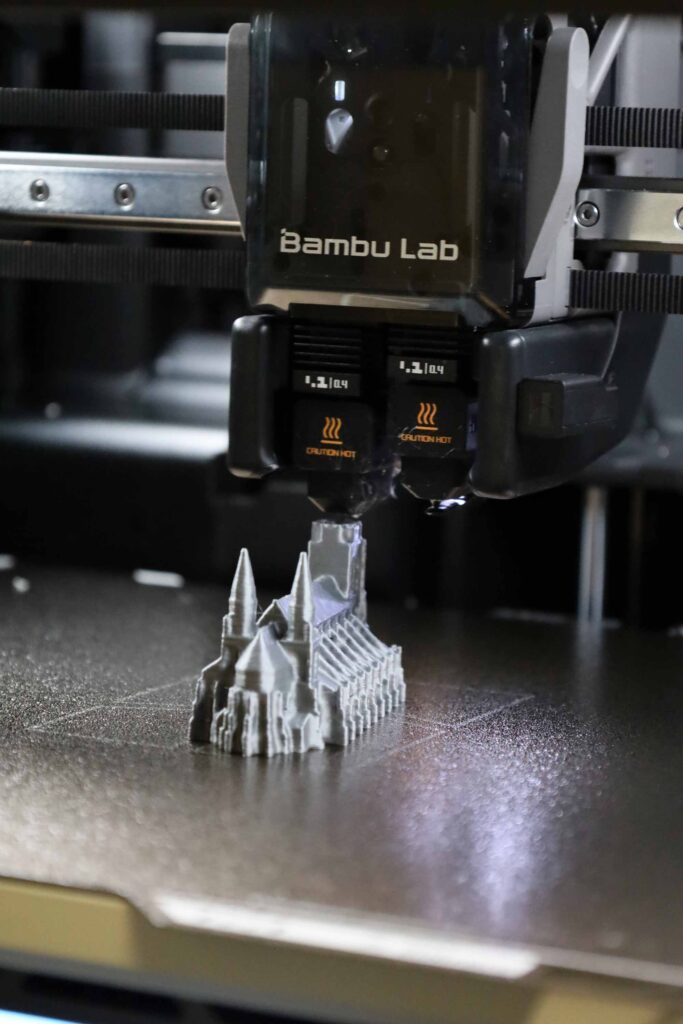 3D Drucker fertigt ein detailliertes Modell einer Kirche auf der Druckplatte.