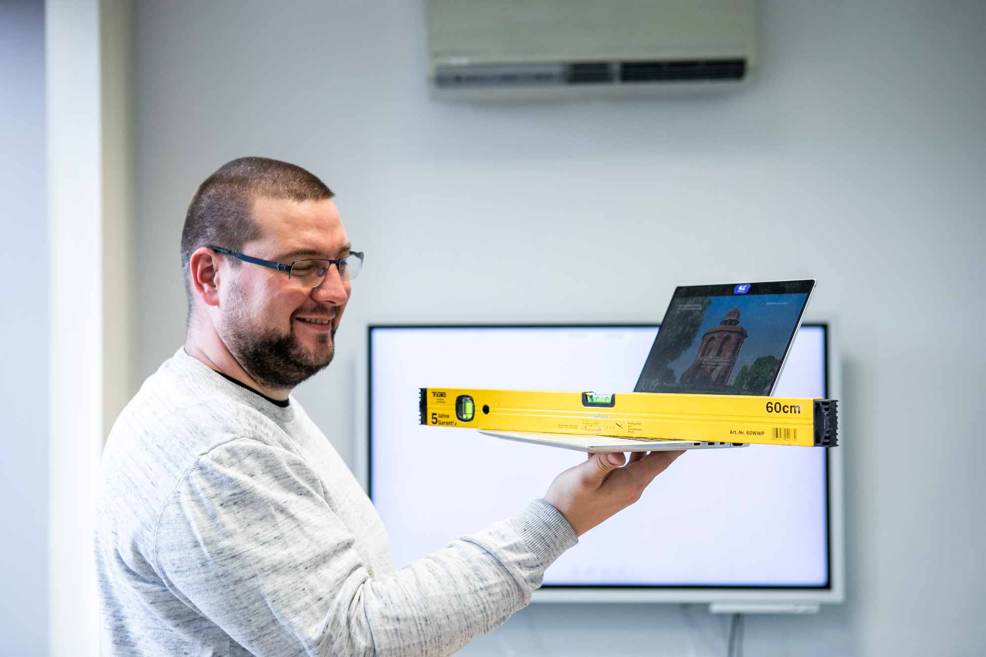 Bim mann nivelliergeraet laptop laechelnd