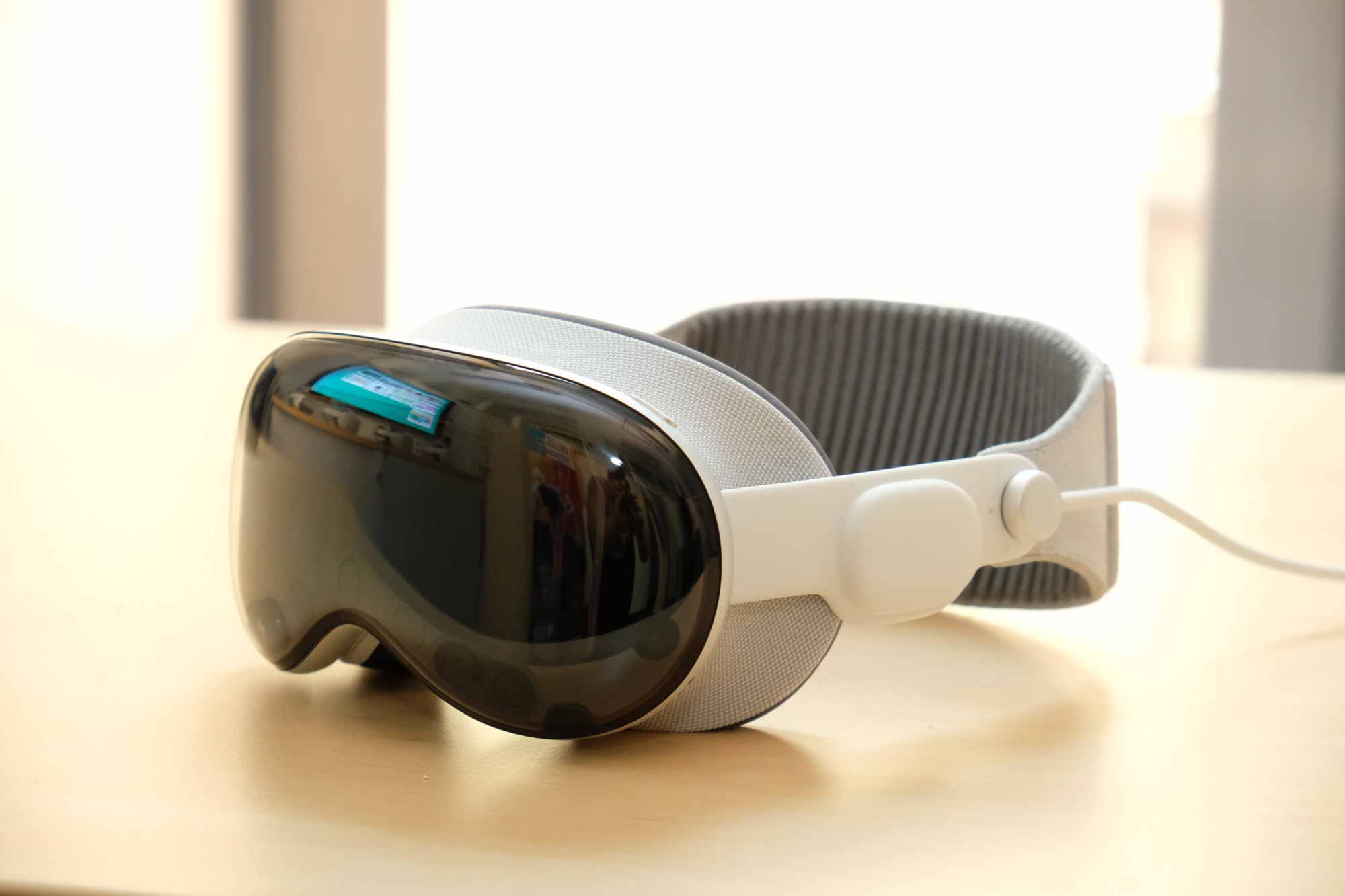 Virtual Reality Brille mit dunklem Visier und gepolstertem Kopfband liegt auf einem Tisch.