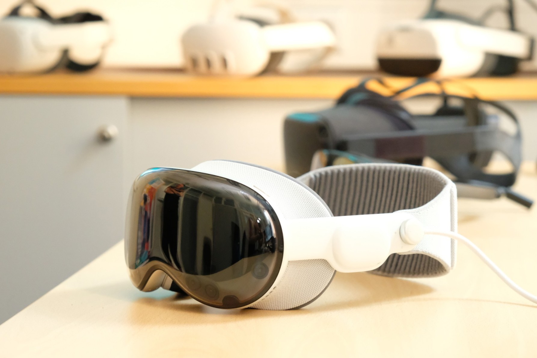Weisse Virtual Reality Brille mit dunkler Front und Kopfband auf einem Tisch.